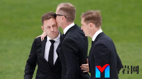 Joel, Adam and Scott Selwood embrace during Troy’s funeral service at GMHBA Stadium.