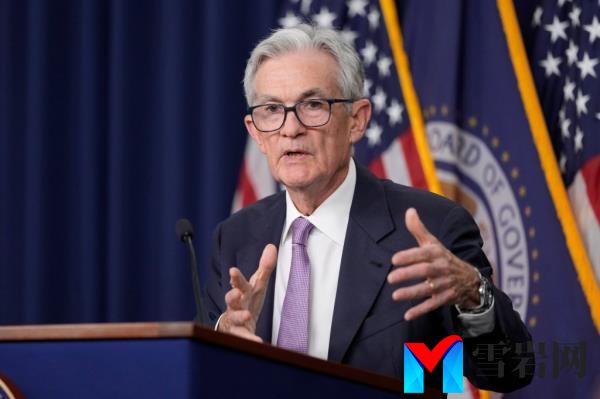 Federal Reserve Board Chairman Jerome Powell speaking at a news co<em></em>nference a<em></em>bout reducing interest rates, gesturing at the podium