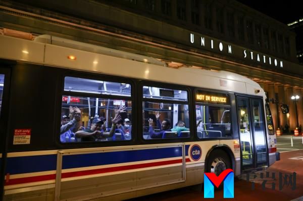Migrants wave as the bus they are heads to a refugee center in Chicago on Aug. 31.