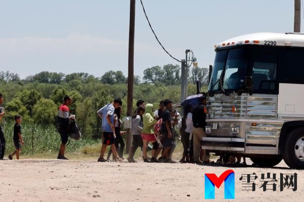 A bus picks up migrants after they crossed the Rio Grande River in Eagle Pass, Texas on July 13. 