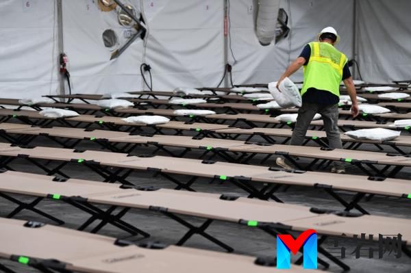 A worker laying out pillows for the cots in the migrant 