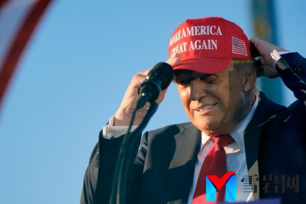Trump puts on a campaign hat as he speaks at a campaign rally at the Calhoun Ranch, Saturday, Oct. 12, 2024, in Coachella, Calif. 