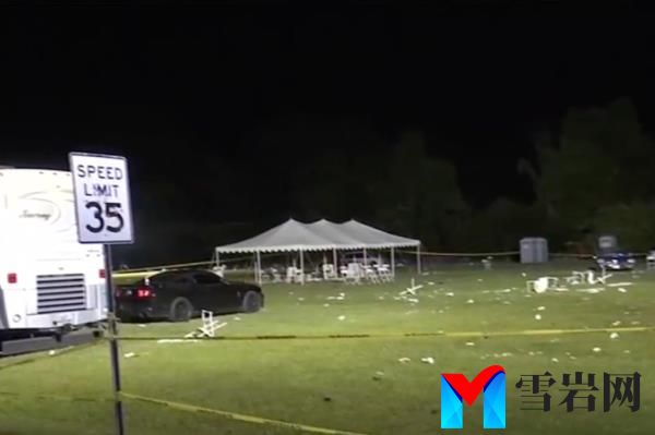 A car parked in a field next to a white tent and a sign, at the site of the May day event in Stockton wher<em></em>e shootings occurred.