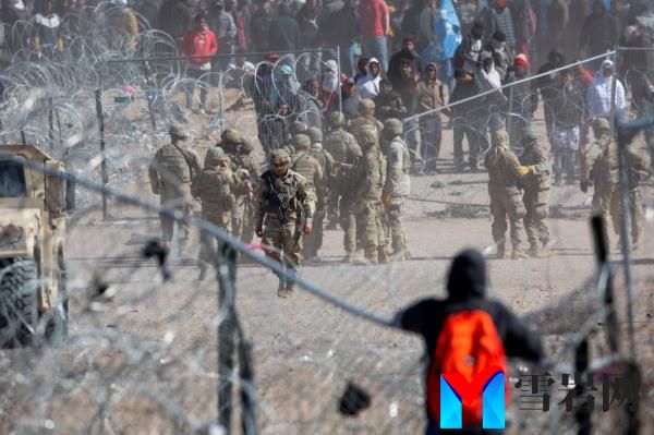 Migrant observing others who have breached the co<em></em>ncertina wire on the Rio Grande in El Paso, Texas during a chaotic border storm