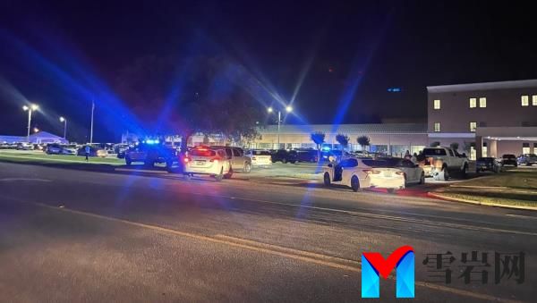 Police cars parked on the side of a road with flashing blue lights during an investigation of a mass shooting event