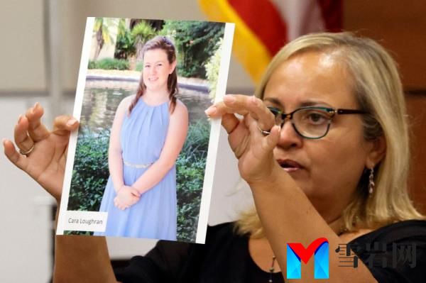 Isabel Dalu holds a photograph of Cara Loughran before giving a victim impact statement on behalf of the Loughran family during the trial.