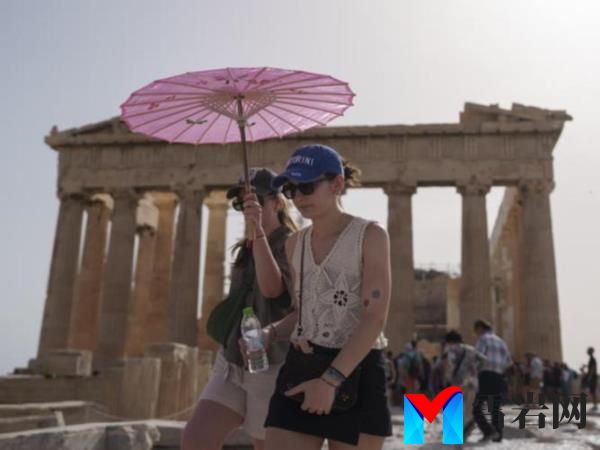 Tourists walk in front of the Parthenon, Athens